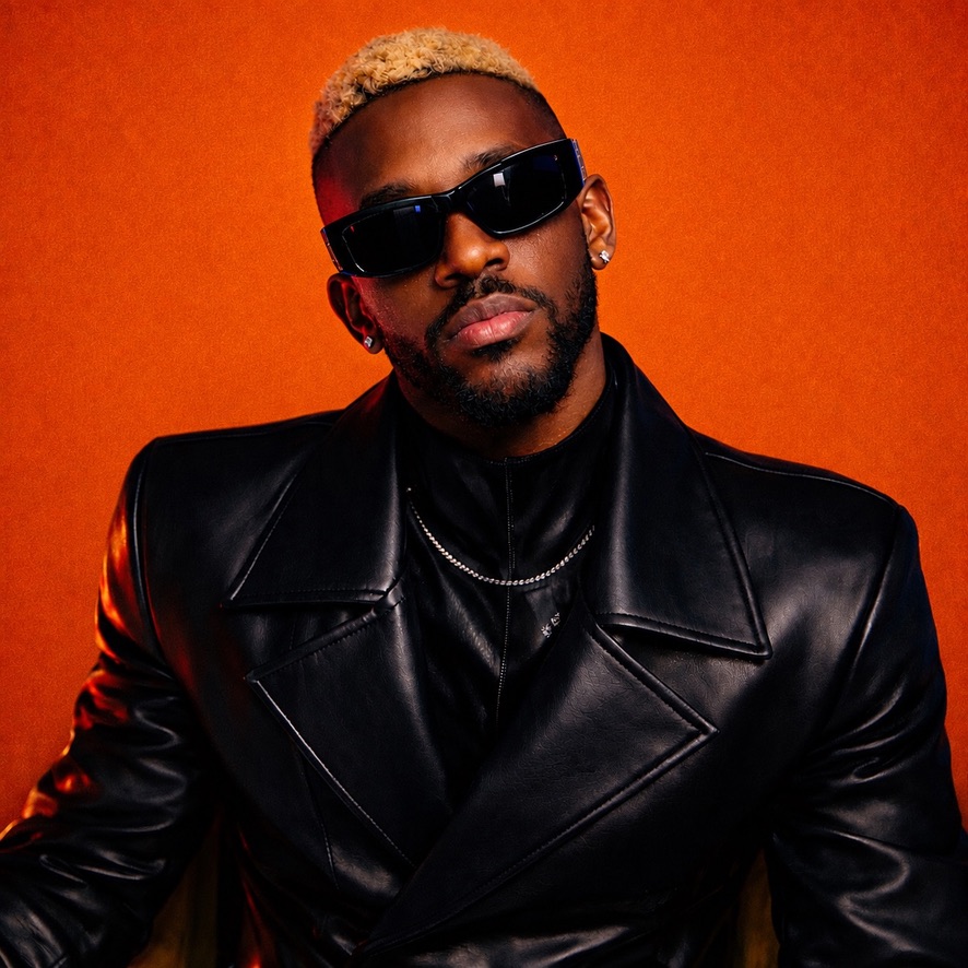 Marc Tovin in sunglasses and black leather against a burnt-orange backdrop